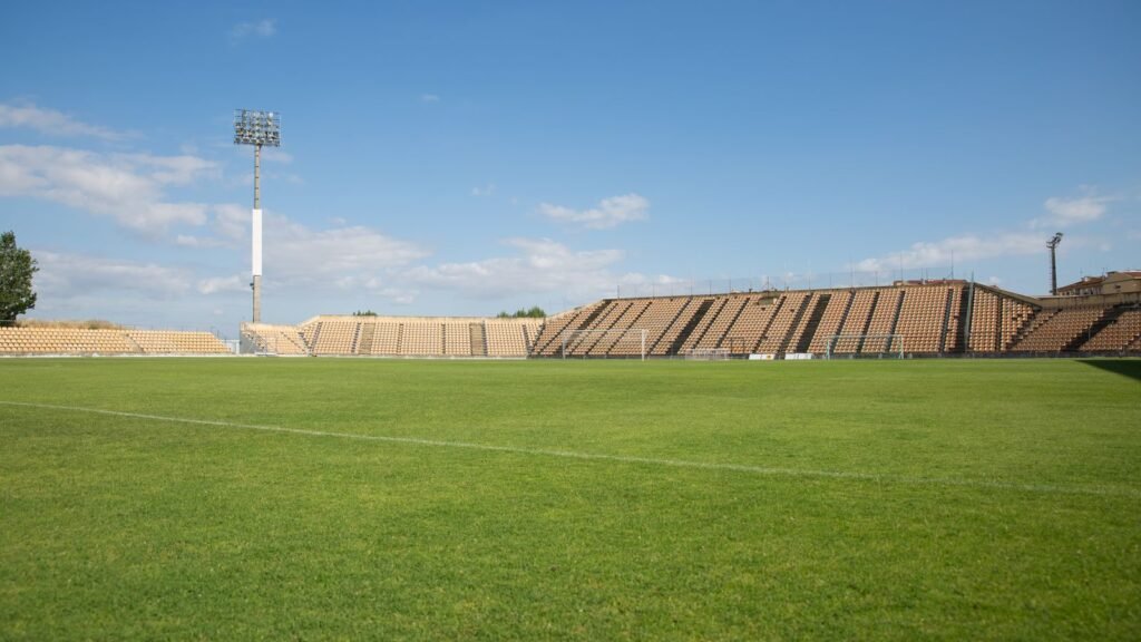Empty football stadium under a clear blue sky