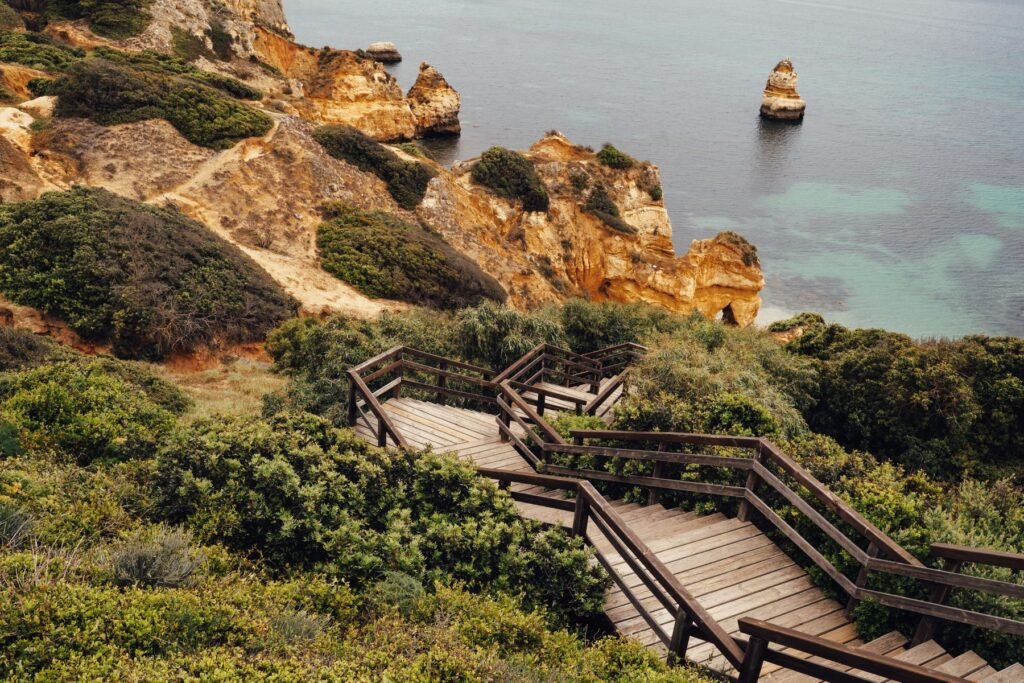 Wooden stairs leading towards Algarve cliffs and sea